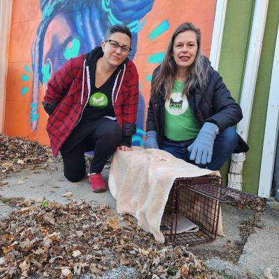 Liz and Erica next to a covered humane trap